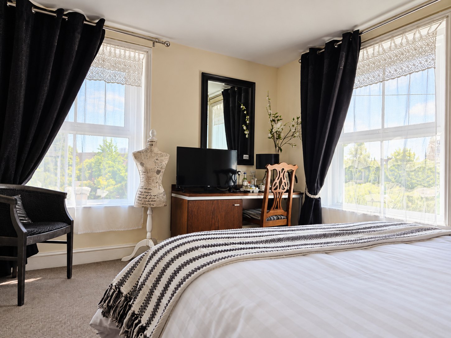 Guest bedroom at The Swan at Compton with twin windows and a seating chair